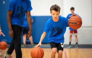 Boy playing basketball with trainer